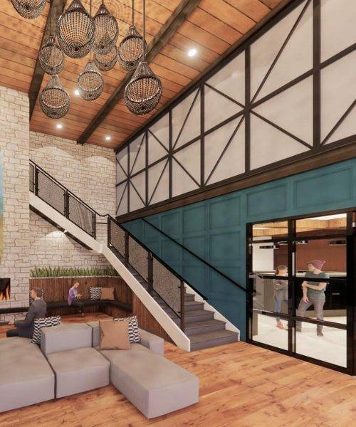 A modern brick apartment building with white-framed windows and a small landscaped garden in front. The building has neatly trimmed bushes, paved walkways, and a tree alongside it. Nearby are additional apartment buildings with a similar design.